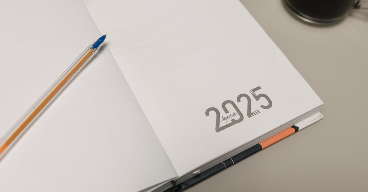 Open 2025 planner with a pen and coffee cup on a desk, ideal for productivity themes.