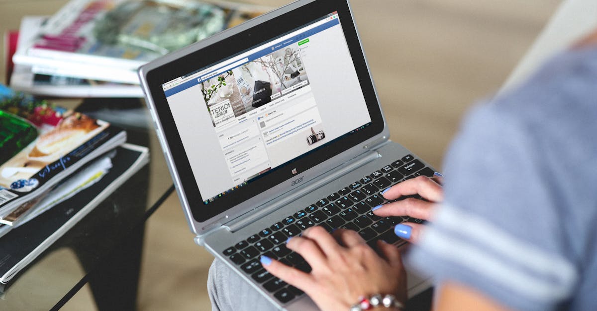 A woman typing on a laptop with social media on the screen, indoors setting.